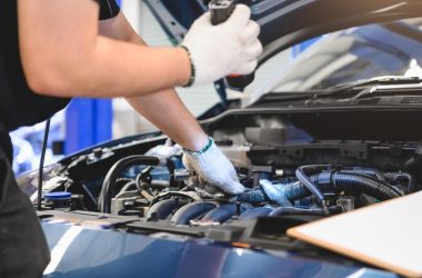 male-mechanic-holds-flashlight-to-examine-car-free-photo